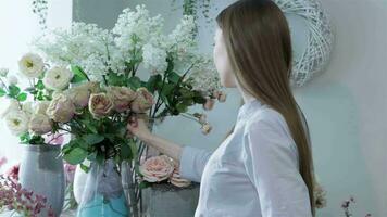 vrouw bloemist regelt bloemen in vazen Bij bloem winkel video