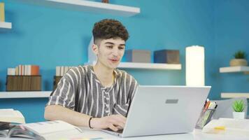 The student looking at the laptop is very happy with what he sees. Makes positive gestures. video