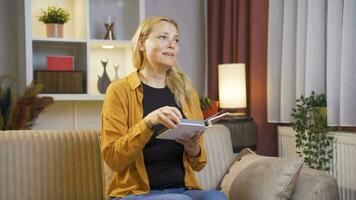 The woman looking at the family album is crying. video