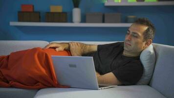 Man using laptop lying down falls asleep. video