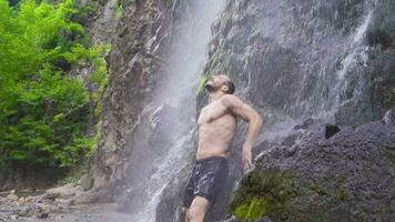 cascada y fuerte hombre en naturaleza. video