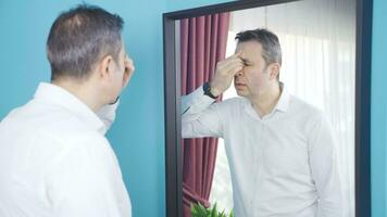 Depressed man looking at himself in the mirror and helpless. video