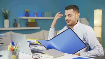 Home office worker man looking at the file angrily. video