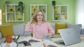 Universidad estudiante niña felizmente viene a su escritorio y empieza estudiando. video