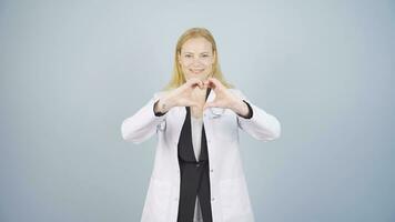 Doctor making heart looking at camera. video