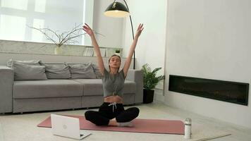 Woman doing physical exercise at home sitting on the floor using online training. video