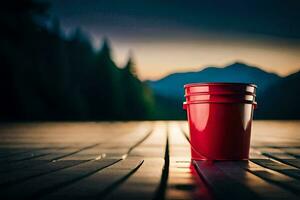 a red bucket sitting on a wooden deck with mountains in the background. AI-Generated photo