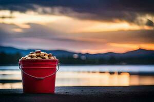 a bucket of nuts on the beach at sunset. AI-Generated photo