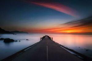 a long pier with a sunset in the background. AI-Generated photo