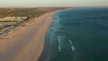 costa da caparica y atlántico Oceano a puesta de sol. Portugal. aéreo vista. zumbido moscas adelante, inclinación arriba. revelar Disparo video