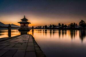 un pagoda se sienta en el borde de un lago a puesta de sol. generado por ai foto