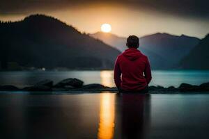 hombre sentado en rocas a puesta de sol con montañas en el antecedentes. generado por ai foto