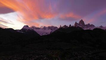 Mount Fitz Roy, Cerro Torre and El Chalten Town at Evening Twilight. Pink Clouds. Hills and Snow-Capped Mountains. Andes, Patagonia, Argentina. Blue Hour. Aerial View. Drone Flies Sideways video