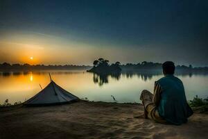 the man is sitting on the sand near a tent and a lake. AI-Generated photo