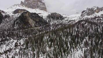 Tre Cime Di Lavaredo. The Three Peaks on Cloudy Winter Day and Forest. Aerial View. Sexten Dolomites, South Tyrol, Italy. Drone Flies Forward, Tilt Up. Reveal Shot. View from the South video