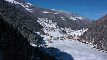 uzungol meer gedekt met ijs in winter. heuvels en bergen met bomen. antenne visie. trabzon provincie, kalkoen. dar vliegt achteruit en omhoog video