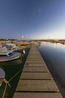 puesta de sol en el puerto de el croata costero pueblo de fazana terminado un embarcadero para barcos en verano noche foto