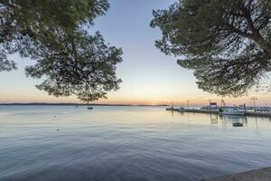 Sunset over the harbor of the Croatian port town of Fazana with a view of the Brijuni Islands photo