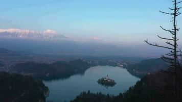 Bled Lake, Marijinega Vnebovzetja Church and Blejski Castle at Sunset. Julian Alps. Slovenia, Europe. View from Velika Osojnica Viewpoint. Aerial View. Drone Flies Forward video