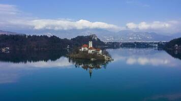 Bled Lake, Marijinega Vnebovzetja Church and Blejski Grad. Julian Alps and Reflection in the Lake. Slovenia. Aerial Hyper Lapse, Time Lapse. Orbiting video