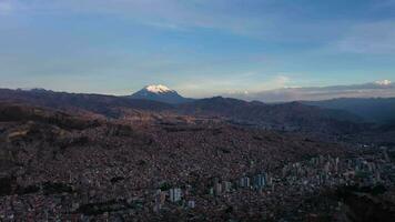 la paz stadsbild och illimani berg. antenn se. bolivia. gyllene timme. Drönare flugor framåt- och nedåt. bred skott. upprättande skott video