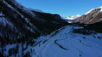 tåg i schweiz i solig vinter- dag. bernina järnväg. swiss alperna. antenn se. Drönare flugor fram, luta upp. avslöja skott video