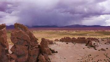 Reisender Mann suchen beim Felsen Formationen im Felsen Schlucht. Bolivien. Antenne Sicht. Drohne fliegt rückwärts. Solo reisen. dramatisch und stürmisch Himmel video