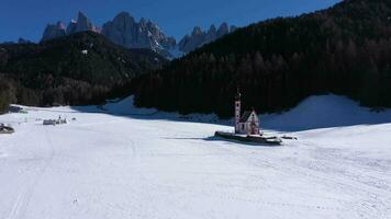 kyrka av st john, skog och dolomiter på solig vinter- dag. söder tyrolen, Italien. antenn se. Drönare flugor framåt- och uppåt video