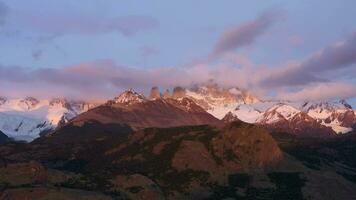 monteren fitz roy in wolken Bij zonsopkomst. heuvels en met sneeuw bedekt bergen. Andes, Patagonië, Argentinië. antenne visie. in een baan om de aarde video