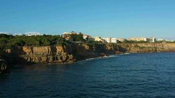 cascais città su soleggiato giorno, scogliere e atlantico oceano. Portogallo. aereo Visualizza. fuco mosche inoltrare e verso l'alto video