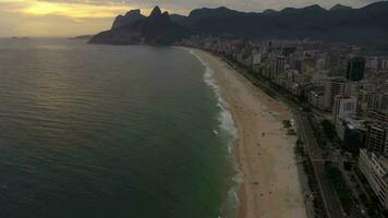 Rio de Janeiro stad. ipanema strand en atlantic oceaan Bij zonsondergang. antenne visie. Brazilië. dar vliegt naar voren, kantelen omhoog. onthullen schot video