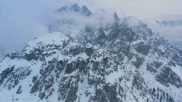 Cadini di Misurina Mountains on Cloudy Winter Day. Aerial View. Sexten Dolomites, Belluno, Italy. Drone Flies Sideways, Tilt Up video