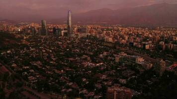 santiago ciudad a noche crepúsculo y Andes montañas. azul hora. aéreo vista. Chile. zumbido moscas adelante, inclinación arriba. revelar Disparo video