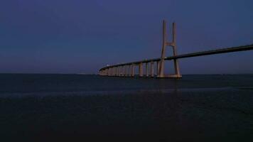 Vasco da jeu haubané pont et tage rivière. soir crépuscule, bleu heure. Lisbonne, le Portugal. aérien voir. drone mouches vers l'avant video