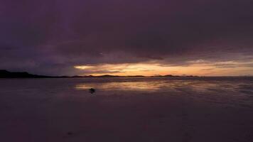 uyuni salt flats och sUV bil på solnedgång. antenn se. altiplano, bolivia. regnig säsong. reflexion på vatten i sjö yta. Drönare flugor framåt- video