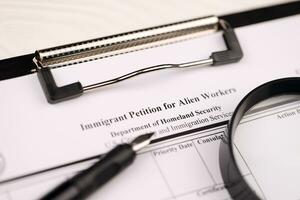 I-140 Immigrant petition for alien workers blank form on A4 tablet lies on office table with pen and magnifying glass photo