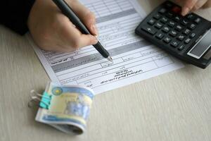 Accountant start to fill Iranian tax form on office table. Taxation period and annual taxpayers routine photo