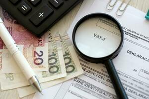 declaración para impuesto en bienes y servicios cuba-7 formar en contador mesa con bolígrafo y polaco zloty dinero cuentas foto