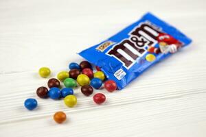 KHARKIV, UKRAINE - JANUARY 2, 2021 M and Ms colorful button shaped chocolate candies. Multi colored chocolates each of which has the letter m printed in lower case in white photo