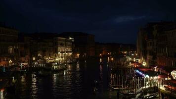 Venedig, Italien - - Februar 19, 2022 beleuchtet großartig Kanal im Venedig beim Nacht. Touristen, Gebäude, Restaurants, Schiffe und Gondeln. Aussicht von Rialto Brücke. Mittel Schuss video