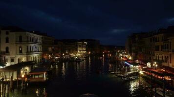 Venedig, Italien - - Februar 19, 2022 beleuchtet großartig Kanal im Venedig beim Nacht. Touristen, Gebäude, Restaurants, Schiffe und Gondeln. Aussicht von Rialto Brücke. breit Schuss video