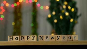 hölzern Block mit das Wörter glücklich Neu Jahr Bokeh Beleuchtung Hintergrund video