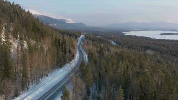 coche en la carretera en invierno día. nevadas montañas. aéreo vista. murmansk región, kola península, Rusia. zumbido moscas adelante video