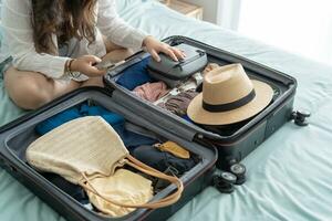 mujer embalaje maleta en cama para un nuevo viaje embalaje lista para viaje planificación preparando vacaciones libro ahora de viaje transporte foto