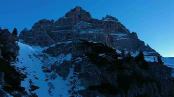 Tre Cime Di Lavaredo. The Three Peaks at Morning Twilight in Winter and Auronzo Hut. Blue Hour. Aerial View. Sexten Dolomites, South Tyrol. Italy. Drone Flies Forward and Upwards. View from the South video