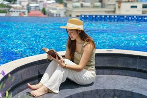 verano fiesta joven asiático hermosa mujer leyendo libro relajante foto