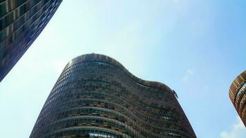 Bottom view of modern skyscrapers in business district against blue sky. Looking up at business buildings in downtown. photo