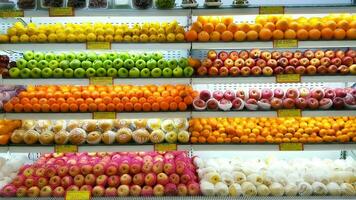 varios tipo de Fresco frutas organizar pulcramente tienda de comestibles almacenar. manzana, naranja, pera, limón en estante. foto