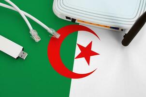 Algeria flag depicted on table with internet rj45 cable, wireless usb wifi adapter and router. Internet connection concept photo