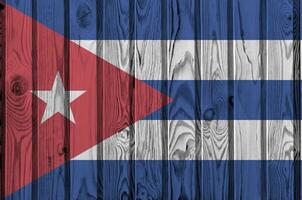Cuba bandera representado en brillante pintar colores en antiguo de madera pared. texturizado bandera en áspero antecedentes foto